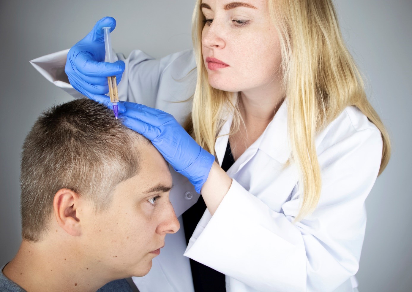 Ważna jest diagnoza, a następnie wybór odpowiedniej formy leczenia. Źródło: Getty Images Leczenie wypadania włosów, lekarz wstrzykuje lek do głowy mężczyzny, pacjenta