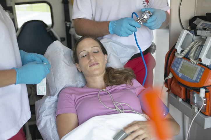 Profesjonalna diagnoza i pomoc. Badanie i monitorowanie parametrów życiowych. Źródło zdjęcia: Getty Images Pacjent w karetce i ratownicy medyczni