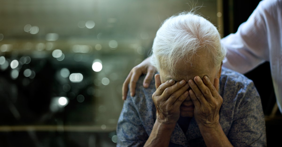 Osoba wykazuje szereg trudności psychicznych i fizycznych. Źródło: Getty Images Starsza kobieta ma problemy zdrowotne, jej głowa jest podtrzymywana przez ręce, a osoba trzyma ją za ramiona