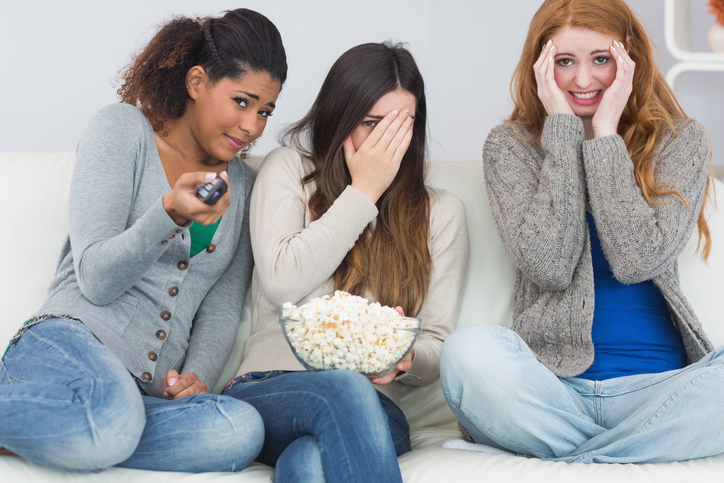 Koszmary z filmu Źródło: Getty Images Trzy dziewczyny są przerażone, oglądają straszny film, popcorn w misce