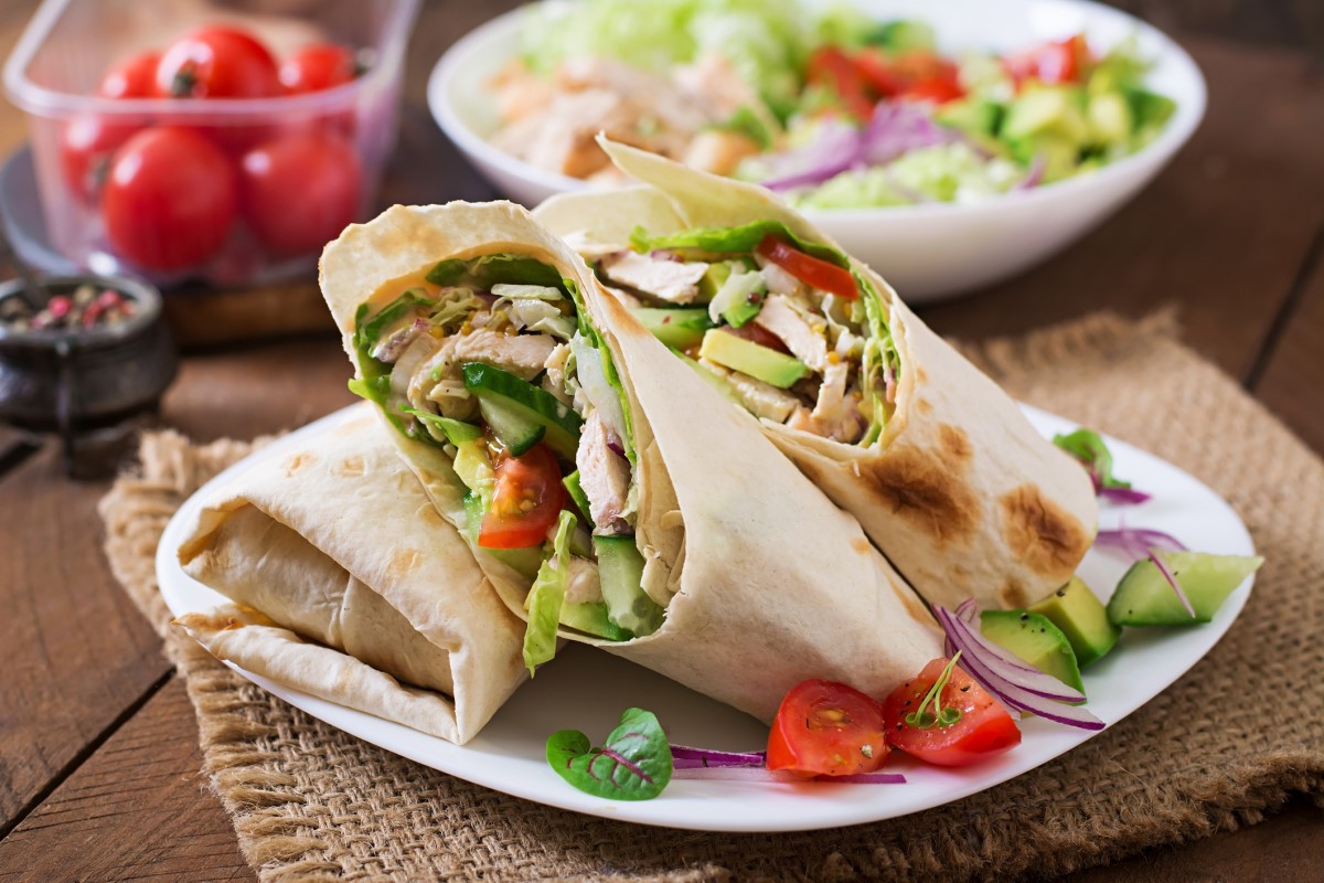 Tortilla pełnoziarnista wypełniona chudym kurczakiem i świeżymi warzywami. Źródło: Getty Images. Pełnoziarnista tortilla wypełniona chudym kurczakiem i świeżymi warzywami.