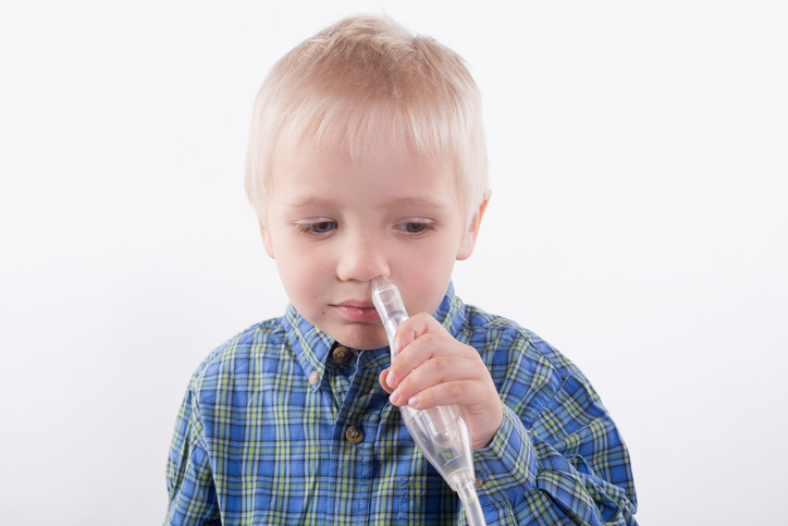 Odciąganie śluzu jest ważne w zapobieganiu powikłaniom. Zdjęcie: Thinkstock photos Chłopiec trzyma odciągacz śluzu przy nosie