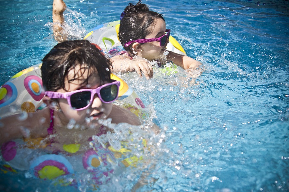 Infekcje ucha dotykają szczególnie dzieci. Zdjęcie: Thinkstock Dwójka dzieci pływa w wodzie. Mają na sobie okulary przeciwsłoneczne w różowych oprawkach i pływają na rowerkach.