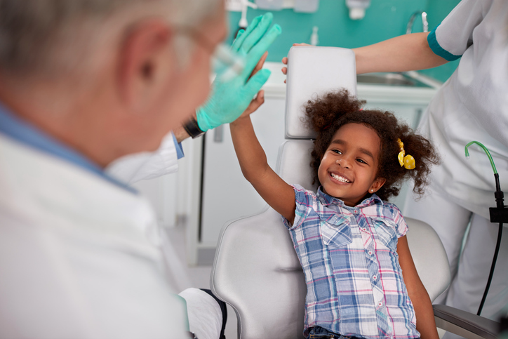Odpowiednia profilaktyka zapobiegnie nieprzyjemnym doświadczeniom dziecka na fotelu dentystycznym. Źródło: Thinkstock roześmiana dziewczyna na fotelu dentystycznym z dentystą.