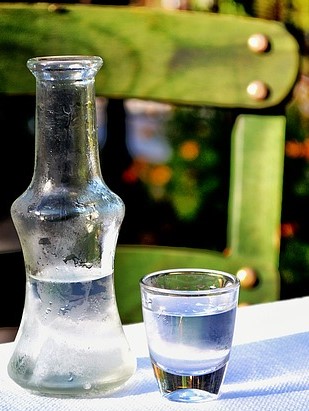 Butelka i kieliszek mocnego trunku, domowej roboty brandy