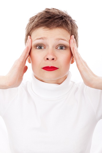 Powiązane bóle głowy, szum w uszach i szum w uszach = badanie. Źródło zdjęcia: Thinkstock Photos kobieta trzyma głowę rękami, boli ją głowa, jej usta są pomalowane na czerwono