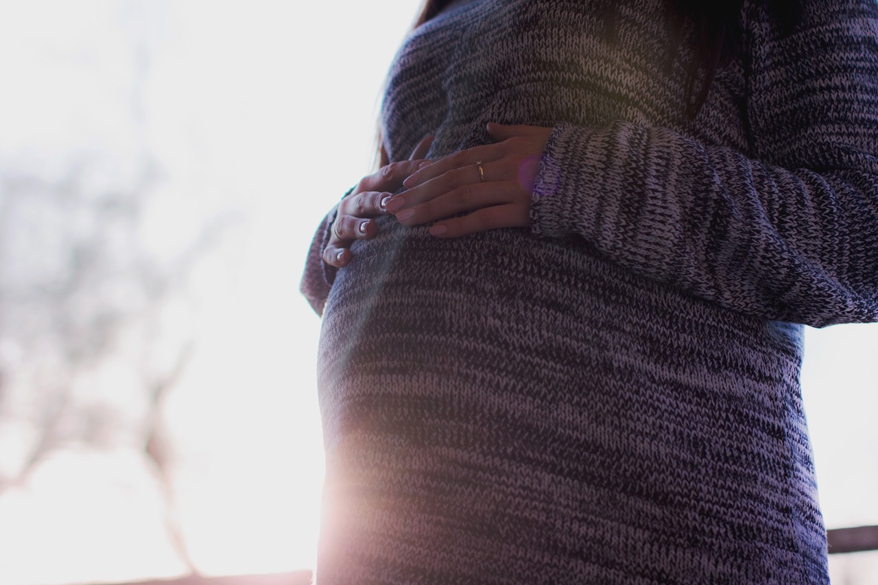 W zmianach hormonalnych, nawet w ciąży. Źródło: Getty Images Kobieta, ciąża, ręce na brzuchu, słońce