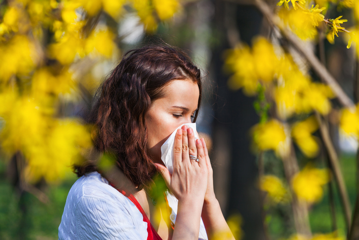 Alergia na pyłki jest częstą przyczyną zatkanego nosa. Źródło: Getty Images Kobieta wydmuchuje zatkany nos z powodu kataru siennego, alergii na pyłki.
